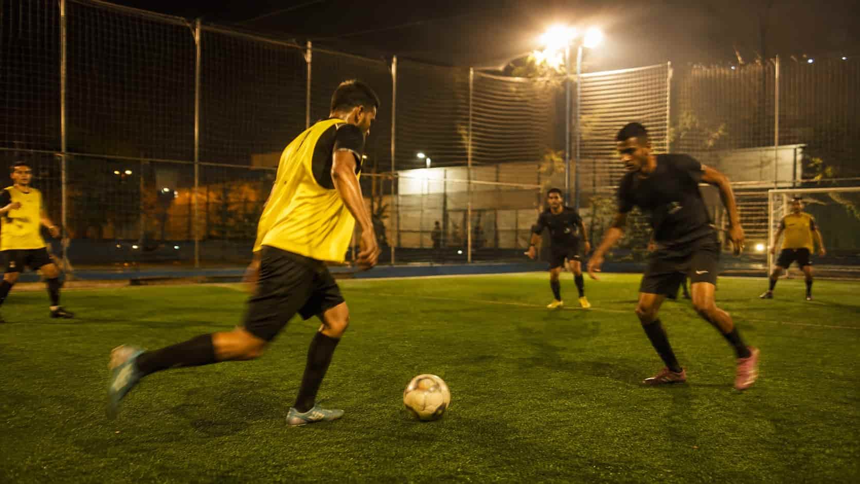 Pelada à noite num campo society iluminado